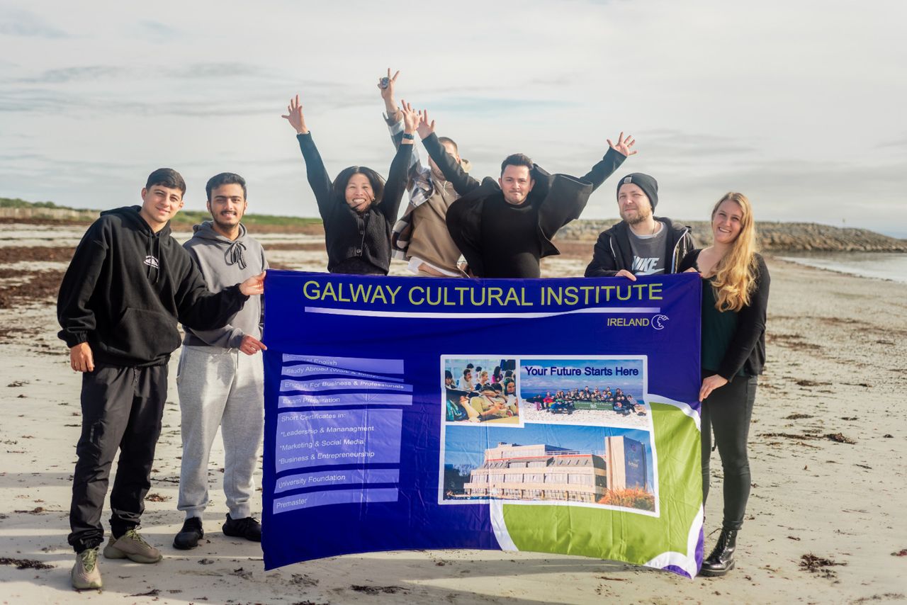 Studenten mit GCI Schild am Strand